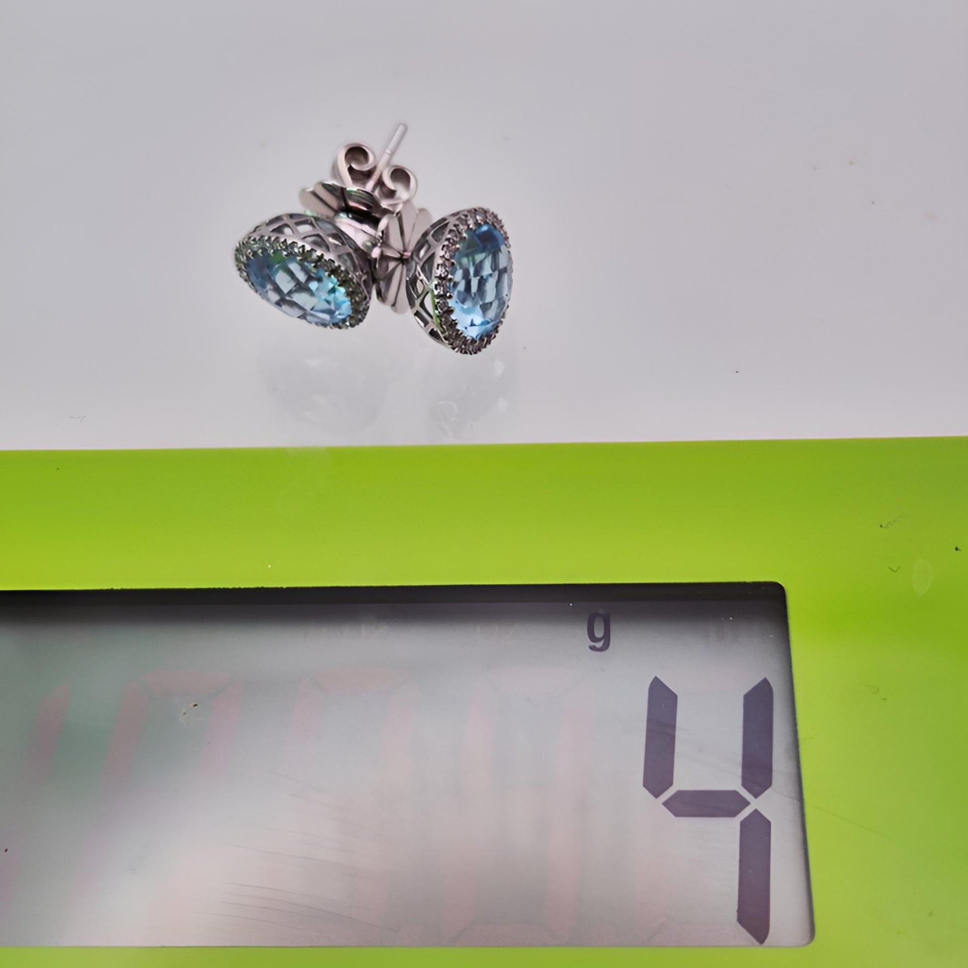 18ct white gold aquamarine and diamond halo cluster stud earrings on scale