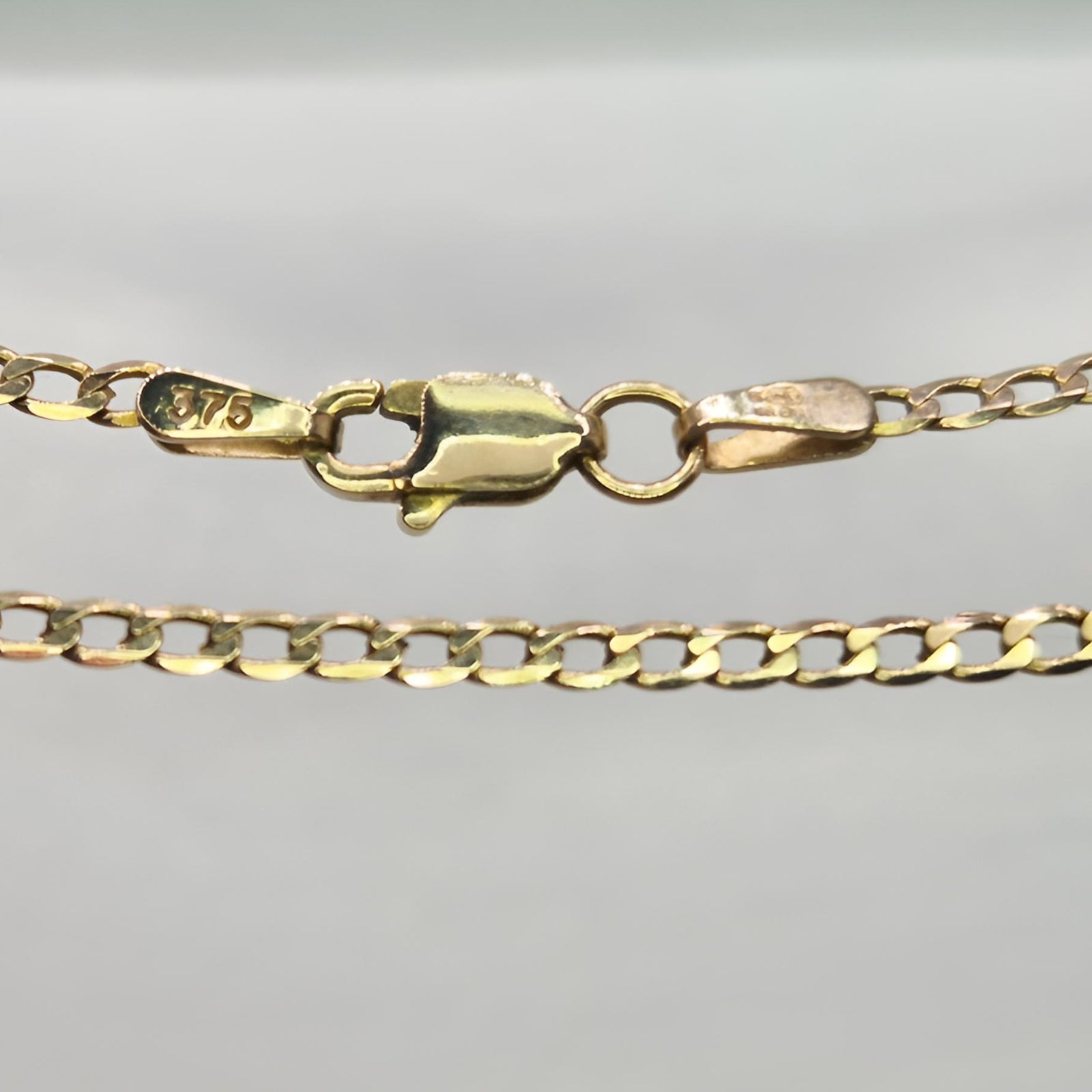 Gold chain with a clasp on a gray background
