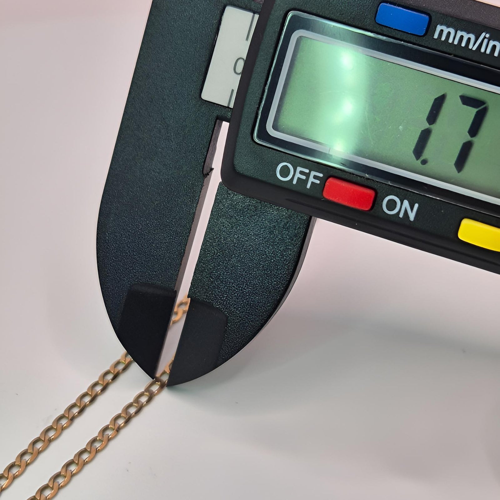 Digital caliper measuring a gold chain with a displayed measurement of 1.7mm.